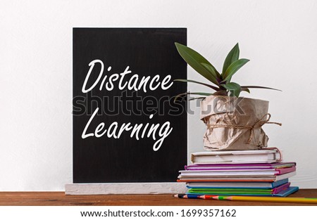 Chalboard Distance learning, books stack, pencils with green home plant in a pot wrapped in brown kraft paper on white background. Online education, quarantine e-learning mockup, back to school banner