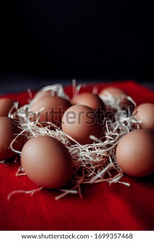 chicken eggs are in a nest with a linen red napkin napkin. lots of chicken brown eggs for easter. Easter eggs.