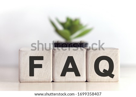 FAQ concept on wooden cubes and flower in a pot in the background Royalty-Free Stock Photo #1699358407