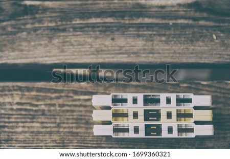 Close-up of 3 cassette tapes from the 80s and 90s, on a wooden background. Image taken from above.Vintage photography