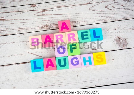 "a barrel of laughs "-the words on wooden cubes.  A background image of english words on colorful building blocks.