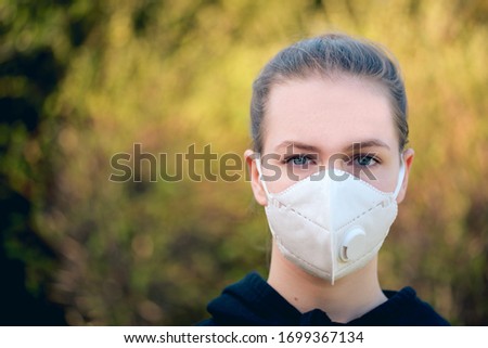 young girl with anti-virus anti-smog mask on her face. Wearing hygiene masks reduces the risk of getting COVID-19 disease caused by coronavirus; it also prevents smog allergies Royalty-Free Stock Photo #1699367134