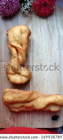 Youtiao or cakwe/ cakoi (or Chinese cruller, fried breadstick/ fritters, oil stick, doughnut, char) on wooden plate