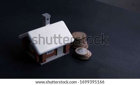 Scandinavian house model put behind the pile of euro coins, mortage loan or  real estate investment concept