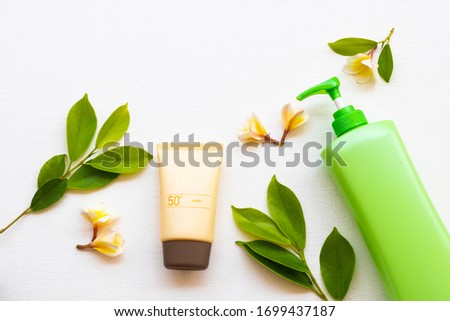sunscreen spf50  cosmetics health care for skin face, body lotion and yellow flowers frangipani of lifestyle woman relax in summer season arrangement flat lay style on background white