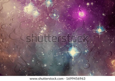 An abstract colored background covered with water droplets.