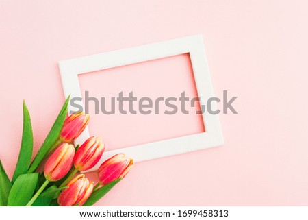 Beautiful spring bouquet of tulips with white wooden frame. Copy space. Flower holiday art design background. Empty space for text. Spring sale. Flat lay. Top view
