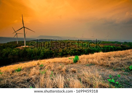 Natural panoramic nature background,high angle viewpoint area, overlooking trees, mountains, large wind turbines,cool wind blurring, abundance of forest