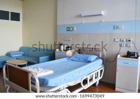 Blurred images of hospital patients room with adjustable beds, blue sofas. Spacious rooms without people. Royalty-Free Stock Photo #1699473049