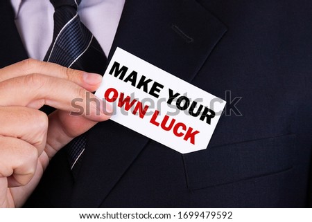 Businessman put card with text Make Your Own Luck in pocket. Business concept.
