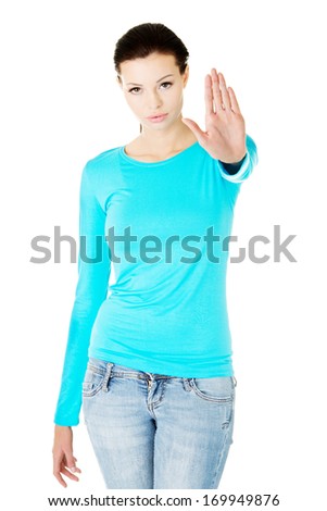 Beautiful casual woman showing stop gesture. Isolated on white.