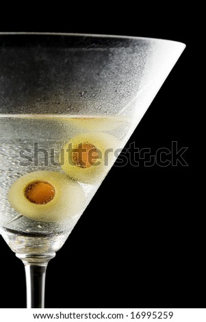 Closeup of a martini with olives on a black background