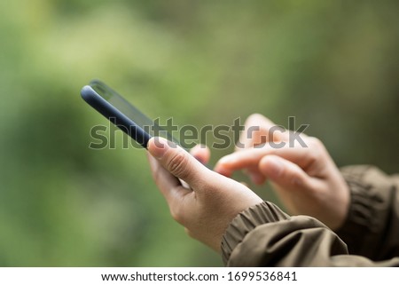 Hands using mobile phone in spring nature