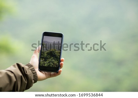 Hiker hands taking picture with mobile phone in spring nature