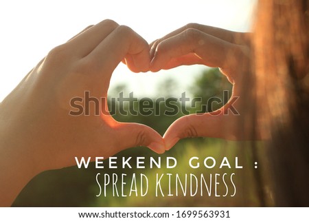 Inspirational motivational quote - Weekend goal, spread kindness. With young woman hands making hand love gesture sign at sunset sunrise. Be kind with heart in hands concept.