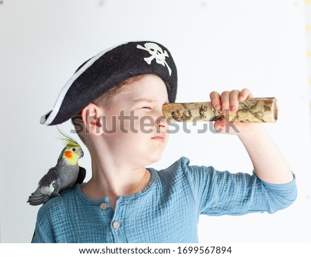 Boy in a pirate hat with a parrot on his shoulder, child actor in the role of a pirate, children's theater club, boy actor