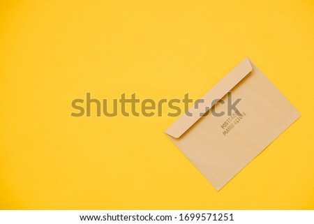 Kraft paper envelope on a yellow background. Perfect for invitations, card, message decorations. Top view. Copy, empty space for text