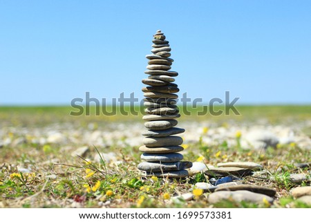 Rock balancing, stone stacks on the beach, blue sky in background