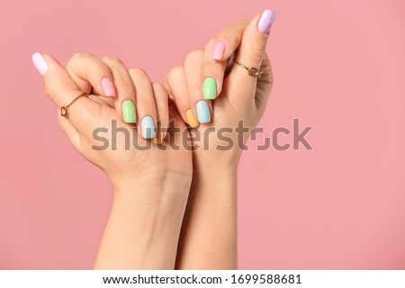 Hands of young woman with beautiful manicure on color background Royalty-Free Stock Photo #1699588681