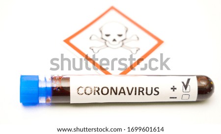 A tube positive for COVID-19 coronavirus pandemic with the hazard sign on the back