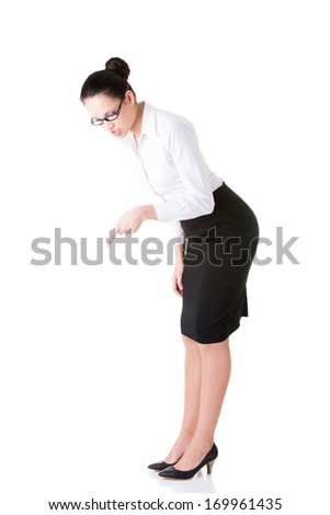 Young business woman bending down and looking. Isolated on white.