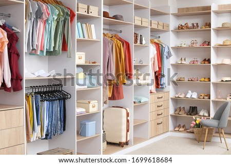 Big wardrobe with different clothes and accessories in dressing room Royalty-Free Stock Photo #1699618684