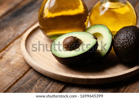 Concept of natural organic oil in cosmetology. Moisturizing skin care and aromatherapy. Gentle body treatment. Atmosphere of harmony relax. Wooden background, avocado. Close up, macro
