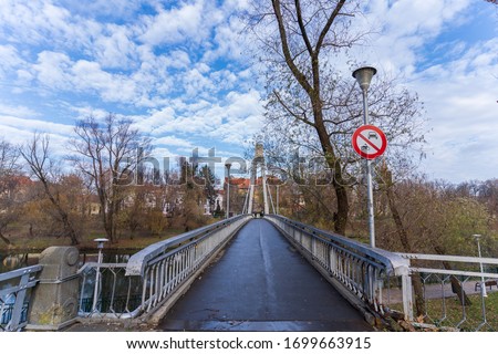 View along a long bridge with iron fence. This bridge, called Intellectuals bridge, has a beautiful legend and is located in Oradea