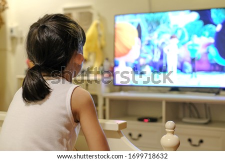 Asian child girl watching a television. cartoon time