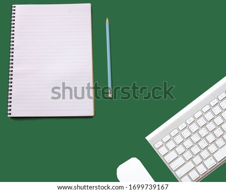 flat lay and close up Computer keyboards ,notebook and pencil on a green background. Business concept and office desk.