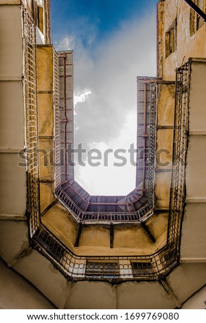 Symmetrical yellow balconies of an old European building and rich blue sky, bottom view