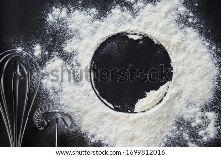 selective focus, copyspace, circle in flour on a dark background with kitchen accessories
