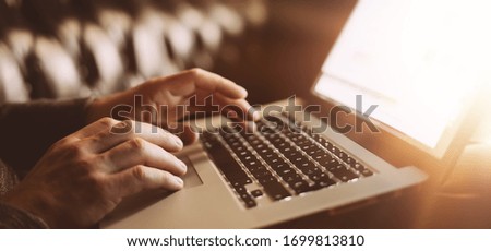 Close-up photo of male hands with laptop. Man is working remotely at home. Distance job