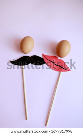 Eggs. Pale pink background. Pictures for a photo shoot, moustache and lips