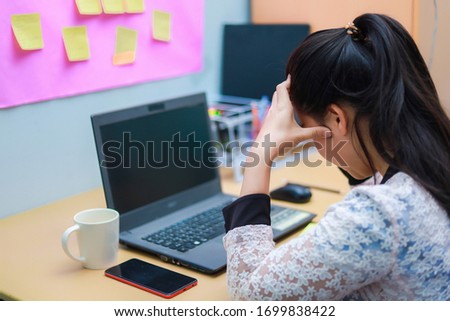 A woman sitting at work with a computer at home with stress, Unhappy person use computer technology at home, Upset woman looking at laptop screen. (out of focus, soft focus) Royalty-Free Stock Photo #1699838422