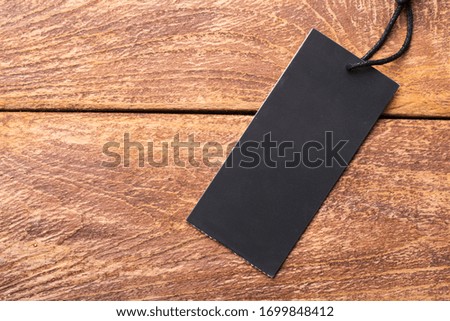 Clothing tag, label blank mockup template on a wooden background