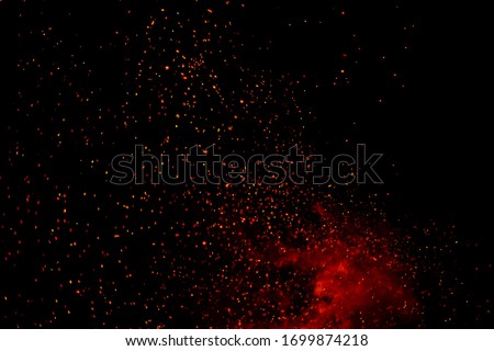 Fire particles effect dust debris isolated on black background, motion powder spray burst. fire flames with sparks. Burning red hot sparks fly from large fire in the night sky.  light and life.