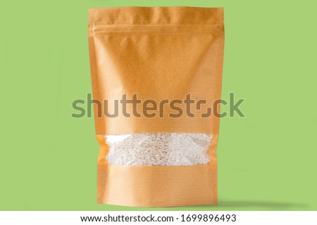 plain brown paper doy pack stand up bio pouch with window on white green background filled with rice Royalty-Free Stock Photo #1699896493