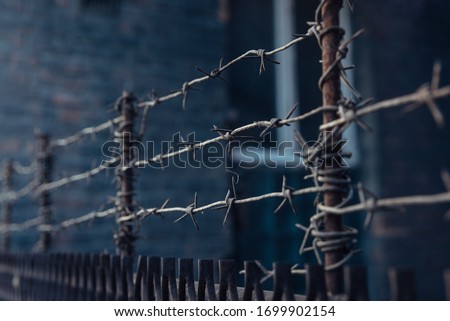 barbed wire stretched in 3 layers on the fence Royalty-Free Stock Photo #1699902154