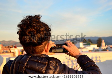 Woman taking pictures of the city of Tetouan from a viewpoint, Morocco