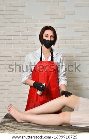 Female beautician during depilation of female legs. Beauty and skin care concept.
