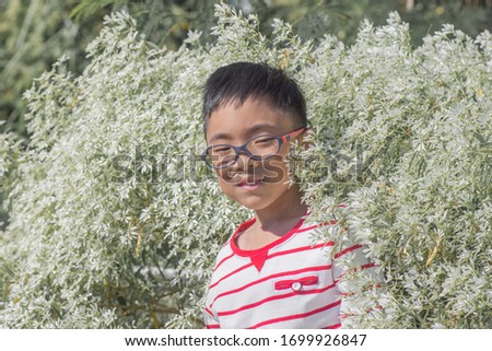 Asian boy Standing and playing in the beautiful flowers
