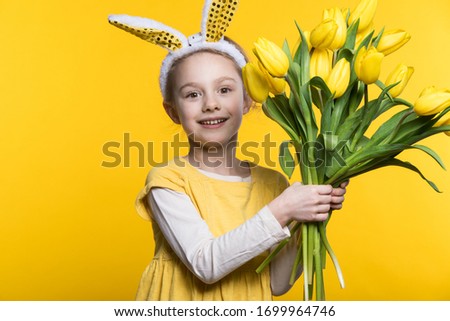 Smiling little girl with bunny ears with flowers