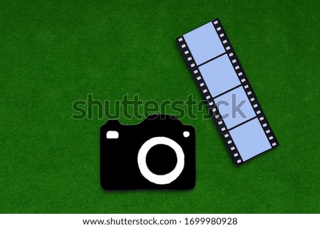Camera, a photographic film on a green background. Passion for photography.