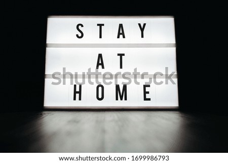 Close-up sign lightbox with letters writing Stay at home in the dark. Quarantine, self isolation and social distancing due to coronavirus or COVID-19 outbreak. 