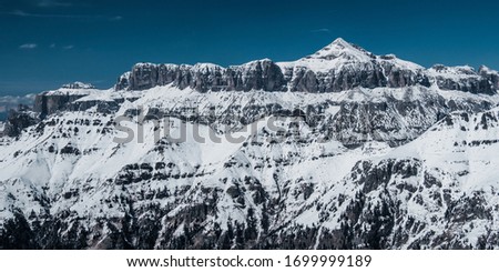  Dolomites in Italy. Beautiful landscape of snowy mountains with cloudy blue sky. Amazing view and panorama shot of rocks and snow.