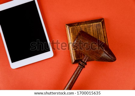 Business office desk with auction wooden gavel and working digital tablet on workspace for auction in the red background