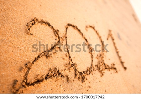 Text 2021 year on the sand of an ocean beach
