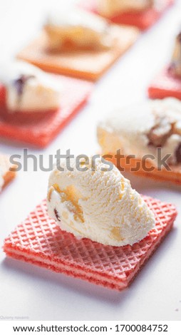 A vertical closeup shot of vanilla ice cream on a pink waffle piece