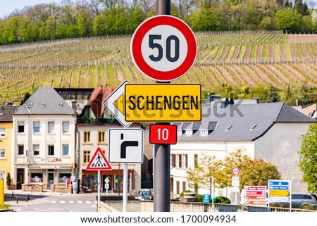 Yellow entrance road sign for Schengen town on the western bank of the river Moselle, Luxembourg. Birthplace of Schengen Agreement, common visa policy, which abolished passport and border control. 